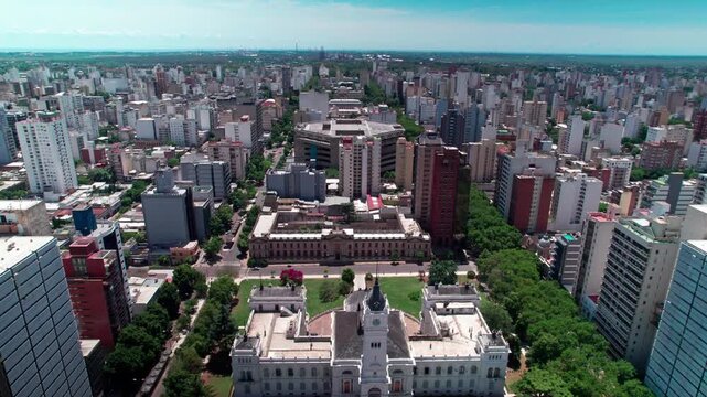 Aerial drone dolly out shot pulling back over Plaza Moreno, exposing the German Neo-Renaissance City Hall, Brutalist Argentino Theater, and planned urban grid in La Plata, Argentina