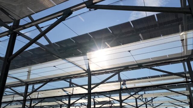 Aerial view of solar panels installed on a metal framework with sun flare in Faenza, Emilia-Romagna, Italy.