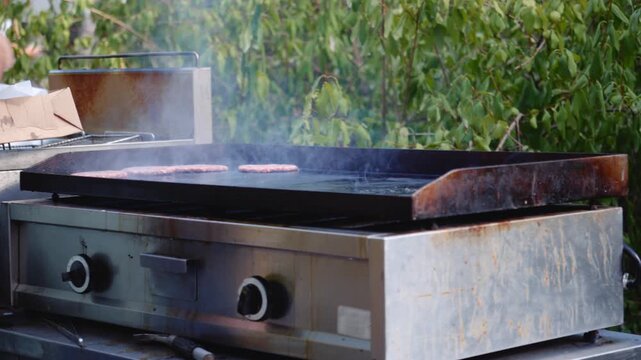 Placing Meat Patties on Outdoor Griddle for Cooking