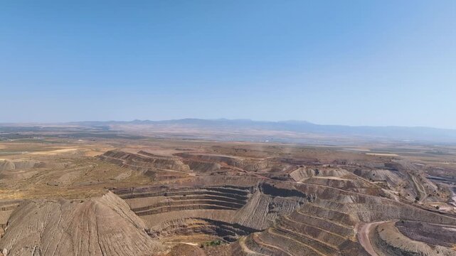Aerial soars above the complex earthworks and dumped slag of a gargantuan iron ore mine in Spain's Granada province, with a vast landscape panorama.