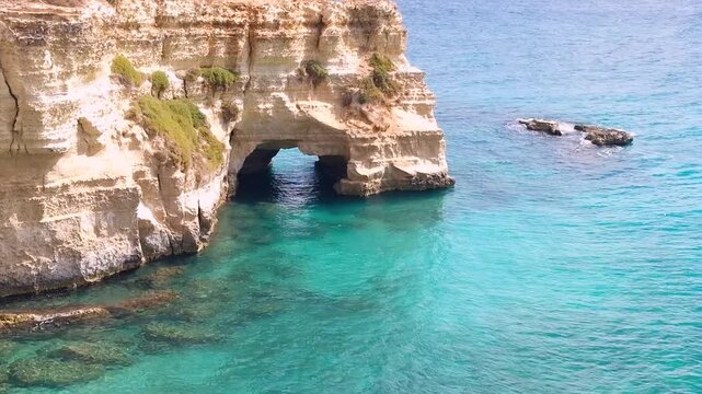 Torre Sant Andrea Otranto Puglia Italy natural rock arch limestone window sea turquoise crystal clear water coastal boulders nature reserve travel 4k video