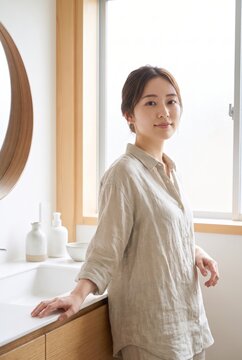 Japanese woman standing beside her bathroom counter