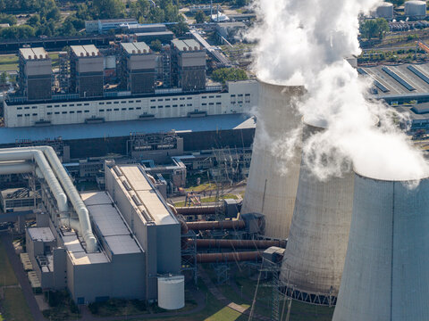 Aerial view of Janschwalde Power Station with large cooling towers emitting steam and industrial infrastructure in Peitz, Brandenburg, Germany.