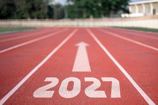Empty running track with 2027 text and forward arrow on red rubber lane, athletic stadium new year concept