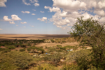 Trockene Kraterebene mit Buschlandschaft und kleinen Gebäuden im Ngorongoro © Jane Be. The Picture