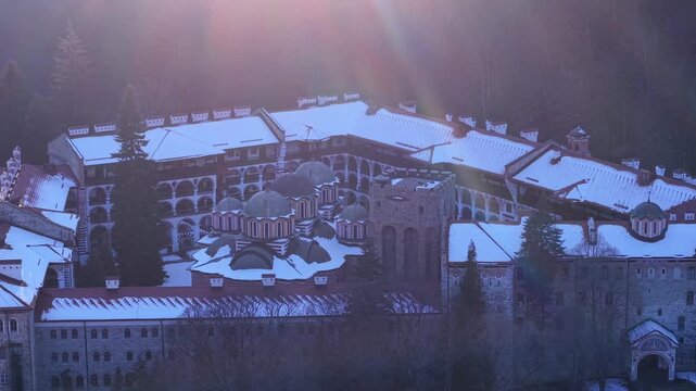 Aerial view of Rila Monastery with snow-covered rooftops and historic stone architecture in Rilski manastir, Kyustendil, Bulgaria.