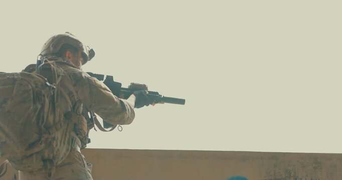 Military tactical operators clear abandoned concrete building with rifles in daylight