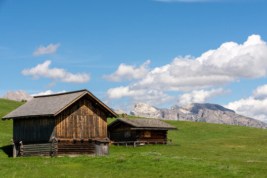 Seis, Italy - August 26, 2026: Wooden cabin with bench overlooking the Seiser Alm