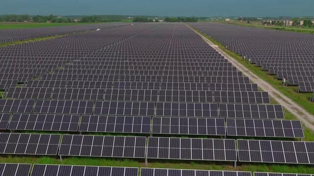 Clear aerial view of photovoltaic panels in orderly rows converting sunlight into electricity &mdash; a simple, readable visual for science lessons, STEM explainers and e-learning.