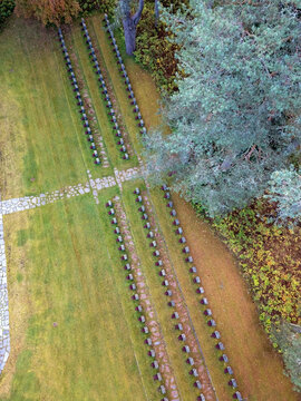 Aerial view of the military cemetery with rows of headstones set in green lawns and stone paths surrounded by pine trees in Muhos, North Ostrobothnia, Finland.