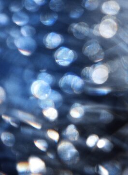 Bokeh grainy background with glowing golden and blue confetti particles, creating a festive party atmosphere for celebrations, events, invitations, banners and creative design.
