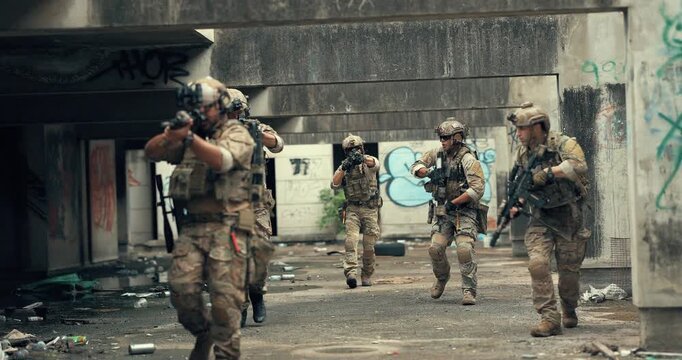 Military tactical squad advances with rifles through corridor of abandoned urban building