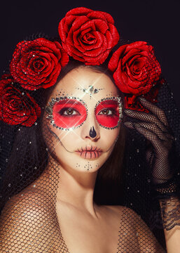 Portrait of a woman with sugar skull makeup over black background. Halloween costume and make-up. Portrait of Calavera Catrina