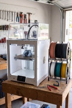 Enclosed 3D Printer Printing Part With Colorful Filament Spools