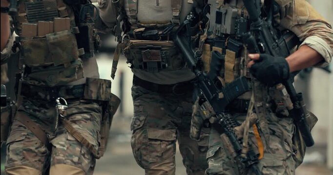 Military team carries wounded teammate to safety while covering the area with rifles