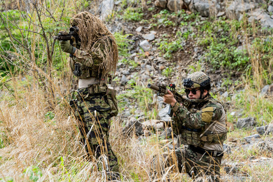 Military training exercise in a natural environment with camouflage gear and weapons