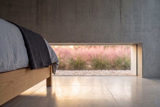 Floor Level Slot Window Framing Pink Muhly Grass in Minimal Bedroom