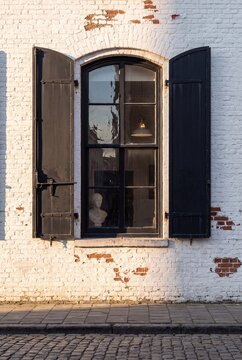 Black Iron Fold Back Shutters Beside Arched Warehouse Window Detail