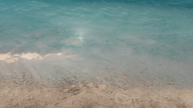 Aerial view of turquoise blue water and intricate sand patterns along the coastline, Denham, Western Australia, Australia.