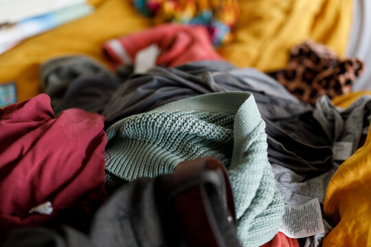 Close-up of a messy pile of colorful clothes, highlighting various textures and fabrics.
