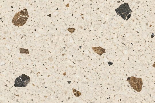 Seamless beige terrazzo texture background with large brown and black marble chips for modern interior design.