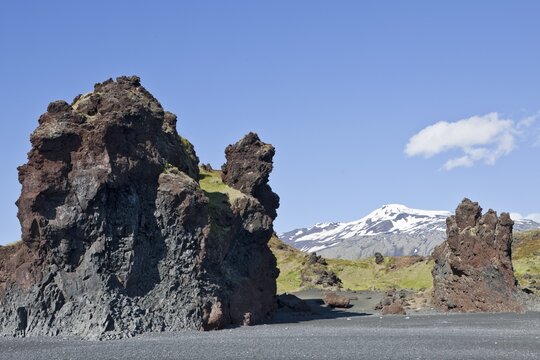 Rock formations on the coast with Sn&aelig;felljoekull volcano, Djupal&oacute;nssandur, Sn&aelig;fellsness, Sn&aelig;fellsnes, Iceland, Europe