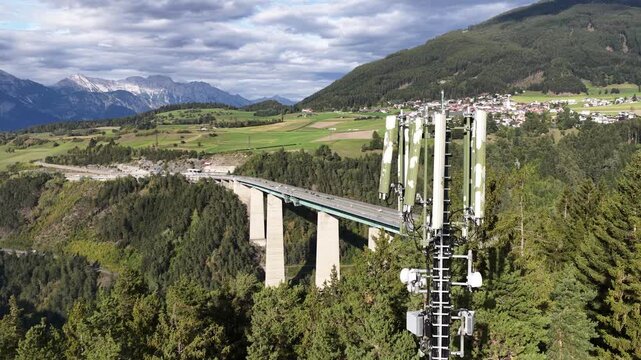 Drone aerial view of the Europa Bridge on the Brenner Autobahn near Innsbruck, Austria, spanning the Wipptal valley with alpine scenery and major transport infrastructure.