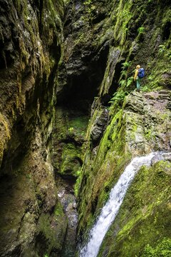 Adventure in nature, hiker in a gorge at PR9 Levada do Caldeir&atilde;o Verde, Madeira, Portugal