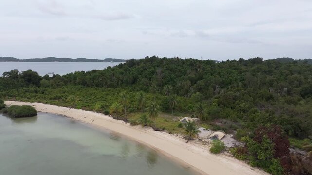 Aerial view of the lush tropical coastline and sandy beach of Batam Island in Batam, Riau Islands, Indonesia.