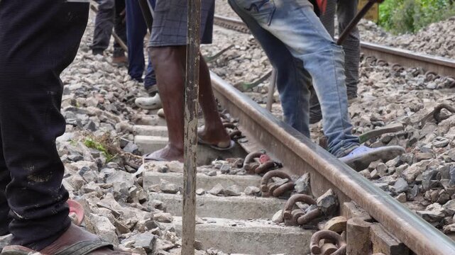 Railway workers performing track maintenance on rail line
