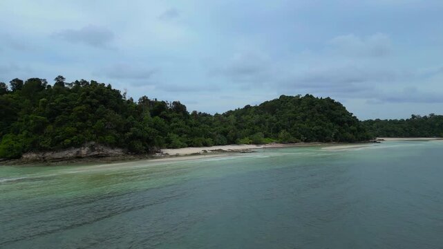 Aerial view of the lush green coastline and calm turquoise waters surrounding Batam Island in Batam, Riau Islands, Indonesia.