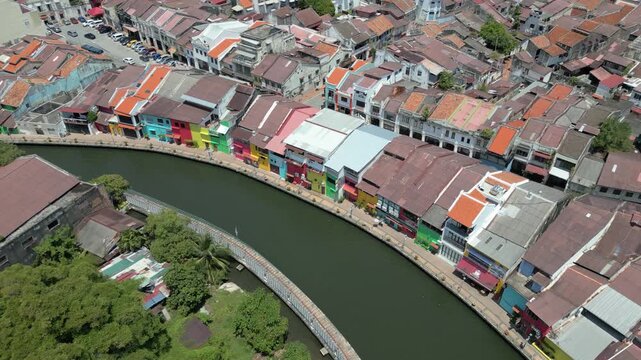Aerial view of the historic Malacca River lined with colorful traditional shophouses and lush greenery in Malacca, Malacca, Malaysia.