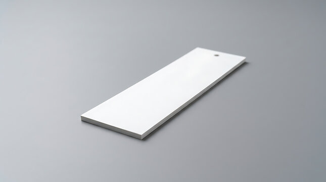 Blank White Paper Bookmark Mockup Resting on a Clean Minimalist Grey Surface with Soft Lighting and Realistic Depth