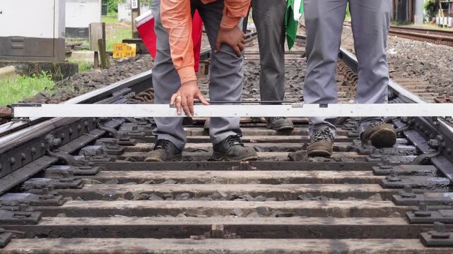 Railway worker measuring track gauge on steel rail