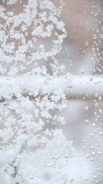 Frosty window, dreamy, coziness and tranquility. Atmosphere is calm and quiet, reflecting the peaceful stillness after a snowstorm. Frosty glass, fluffy snow, post-blizzard,  quiet winter,