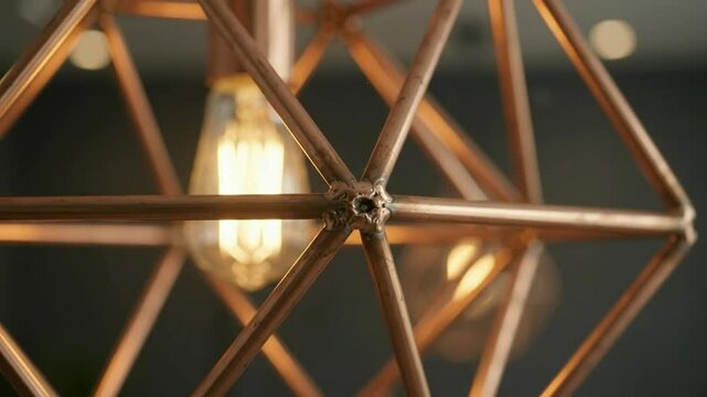 Geometric copper chandelier glowing softly indoors