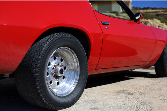 Low angle, side view of the red, american muscle car