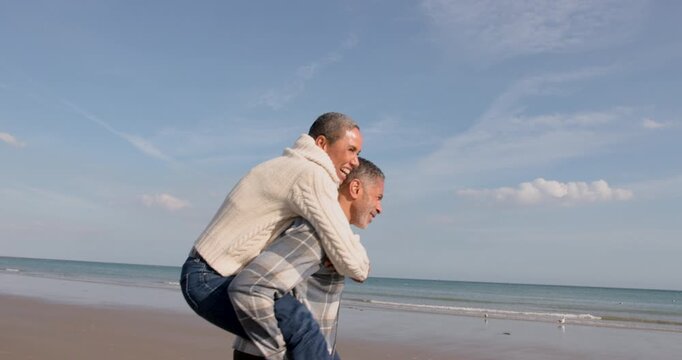 Playful Senior Couple Enjoying Beach Together