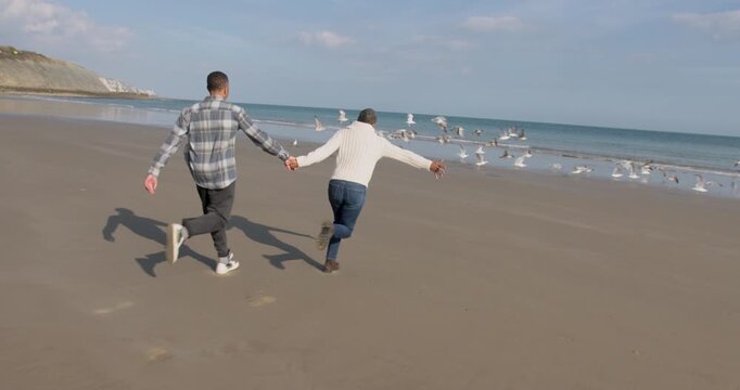 Senior Couple Couple Running Along the Beach Together