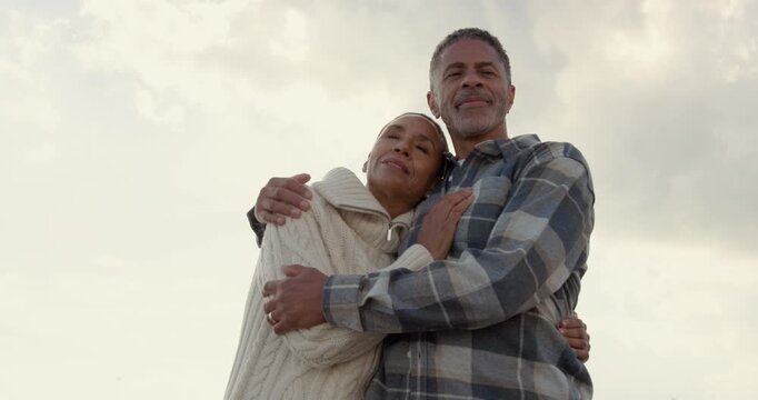 Senior Couple Embracing Against Scenic Sky