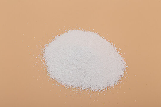 Sodium percarbonate powder in beige background.
