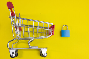 shopping cart with a padlock, symbolizing credit restrictions, controlled spending, shopping limits, frugal living, consumer debt, restricted purchases, and market access limitations. © bizdof photo
