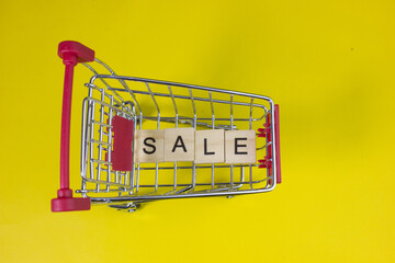 Shopping cart with SALE text, representing limited-time discounts, flash sales, special offers, promotions, supermarket shopping, price reductions, and attractive retail deals for consumers. © bizdof photo
