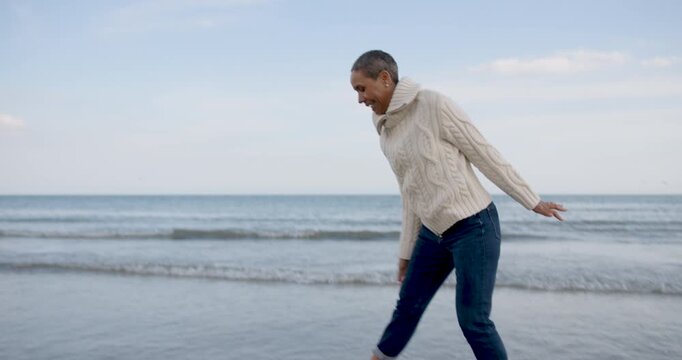 Mature Woman Playing in the Ocean Waves Joyfully