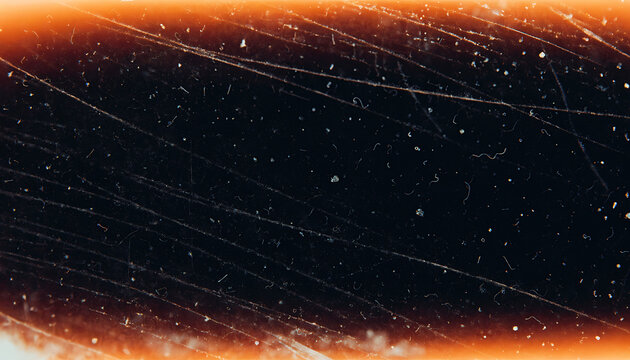 Macro shot of scratched and dusty analog film texture with warm orange border