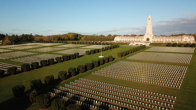 Aerial view of the Douaumont Ossuary, a memorial for World War I soldiers, surrounded by rows of white crosses in a military cemetery in Douaumont-Vaux, Grand Est, France.