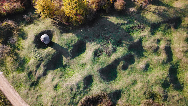 Aerial view of the historic World War I battlefield featuring numerous shell craters, grassy terrain, and autumn trees in Douaumont-Vaux, Grand Est, France.
