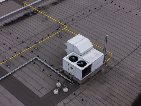 Aerial view of HVAC units and yellow pipes on a flat rooftop in Gdansk, Poland.