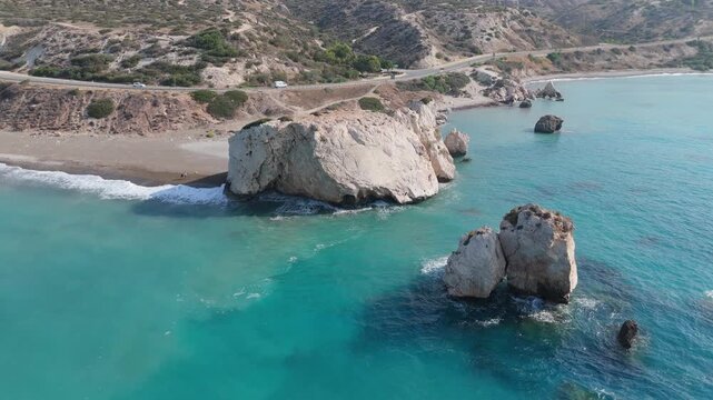 Aerial view of Aphrodite's Rock, a famous sea stack off the coast of Paphos, surrounded by turquoise Mediterranean waters, sandy beaches, and rugged coastal cliffs in Paphos, Paphos, Cyprus.