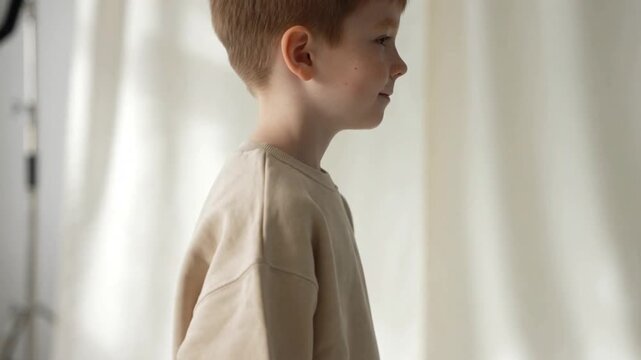 Portrait of a cute boy wearing blank beige sweatshirt mockup